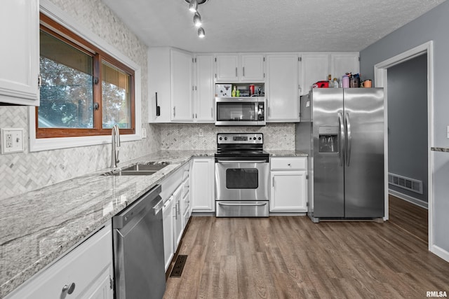 5721 Taylor St, Davenport, IA 52806 - kitchen featuring stainless steel appliances, a sink, light stone counters, white cabinets, and a textured ceiling