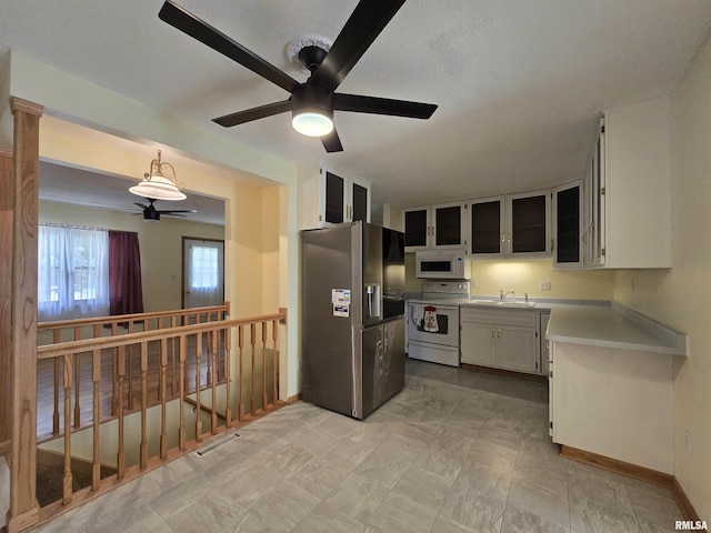 1907 S 15th Ave, Clinton, IA 52732 - kitchen with white appliances, a ceiling fan, light countertops, glass insert cabinets, and a sink
