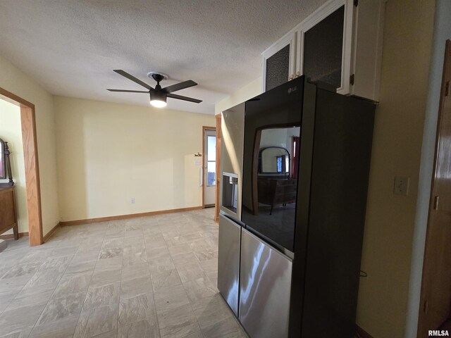 1907 S 15th Ave, Clinton, IA 52732 - kitchen with stainless steel fridge, ceiling fan, a textured ceiling, and baseboards