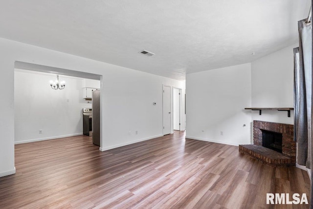 3069 4th St Unit 4, Moline, IL 61265 - unfurnished living room with a fireplace, a chandelier, and wood finished floors