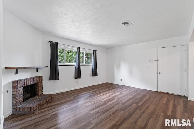 3069 4th St Unit 4, Moline, IL 61265 - unfurnished living room with wood finished floors, a fireplace, and a textured ceiling