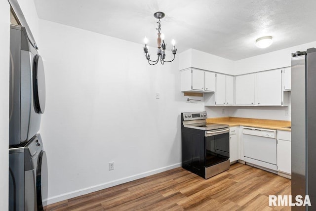 3069 4th St Unit 4, Moline, IL 61265 - kitchen with stainless steel appliances, stacked washer and clothes dryer, light countertops, white cabinets, and light wood finished floors