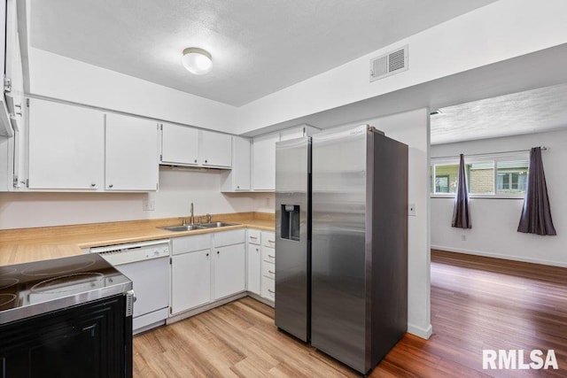 3069 4th St Unit 4, Moline, IL 61265 - kitchen with stainless steel fridge with ice dispenser, white dishwasher, light wood finished floors, light countertops, and a textured ceiling
