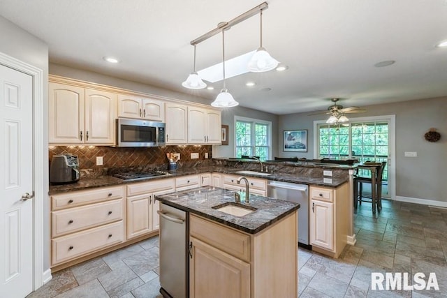 461 45th Ave, East Moline, IL 61244 - kitchen featuring stainless steel appliances, a peninsula, stone tile floors, tasteful backsplash, and a sink