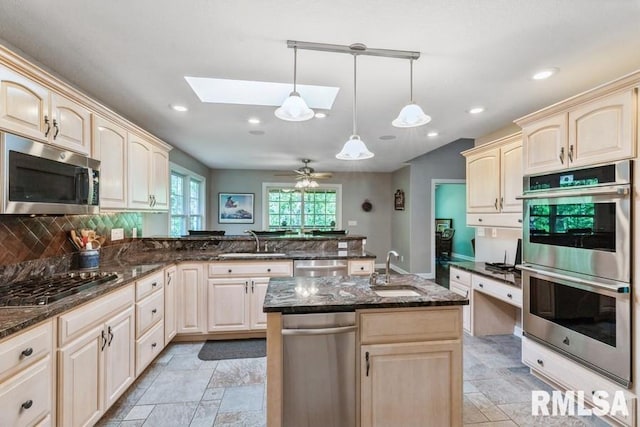 461 45th Ave, East Moline, IL 61244 - kitchen featuring appliances with stainless steel finishes, a sink, a peninsula, a skylight, and recessed lighting
