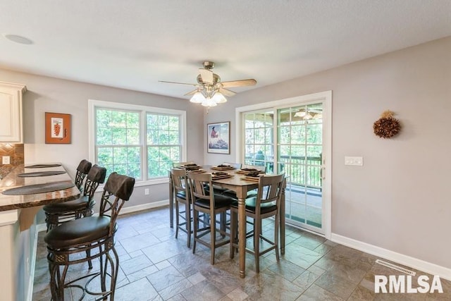 461 45th Ave, East Moline, IL 61244 - dining space with baseboards, stone tile flooring, and a ceiling fan