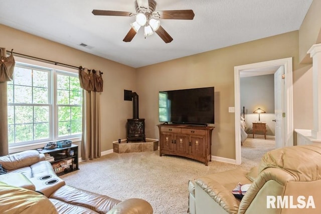 461 45th Ave, East Moline, IL 61244 - living area with a wood stove, light colored carpet, a ceiling fan, and baseboards