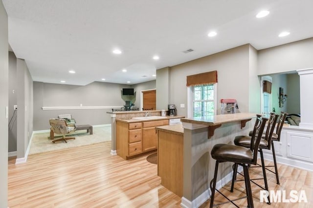 461 45th Ave, East Moline, IL 61244 - kitchen with light wood-style flooring, a kitchen breakfast bar, a center island, recessed lighting, and light countertops