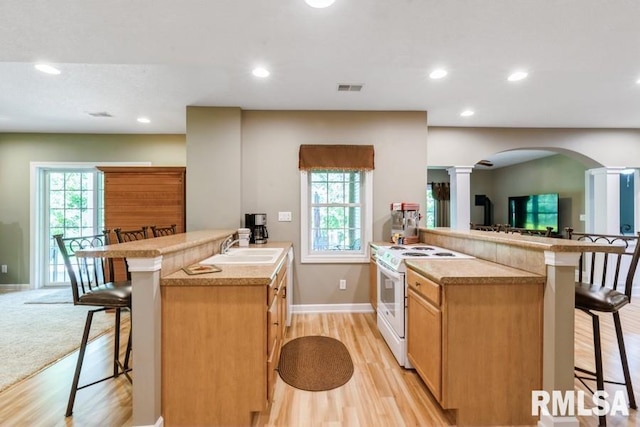 461 45th Ave, East Moline, IL 61244 - kitchen with electric range, decorative columns, a peninsula, a breakfast bar area, and arched walkways