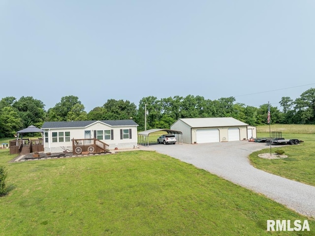 11271 W Center Rd, Mulkeytown, IL 62865 - view of front of property with a carport, a front lawn, an outbuilding, view of scattered trees, and a garage