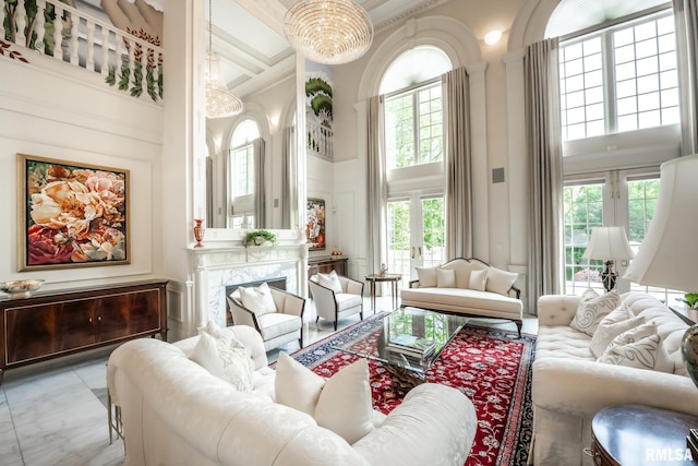 2 Hickory Ct, Rock Island, IL 61201 - living room featuring a towering ceiling, a decorative wall, marble look tiles, a chandelier, and crown molding