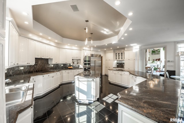 2 Hickory Ct, Rock Island, IL 61201 - kitchen featuring a sink, a tray ceiling, tasteful backsplash, appliances with stainless steel finishes, and a large island with sink