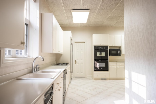 2 Hickory Ct, Rock Island, IL 61201 - kitchen featuring black appliances, a sink, white cabinets, light countertops, and light tile patterned floors