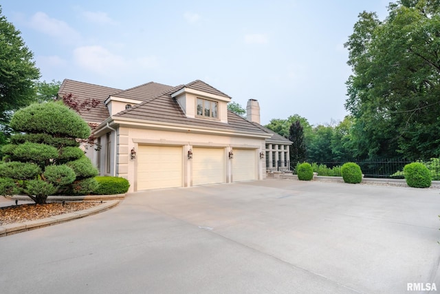 2 Hickory Ct, Rock Island, IL 61201 - view of front of home featuring concrete driveway, stucco siding, a chimney, and a tiled roof