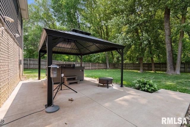5300 Hillandale Rd, Davenport, IA 52806 - fenced backyard featuring a hot tub, a gazebo, a patio area, and an outdoor fire pit