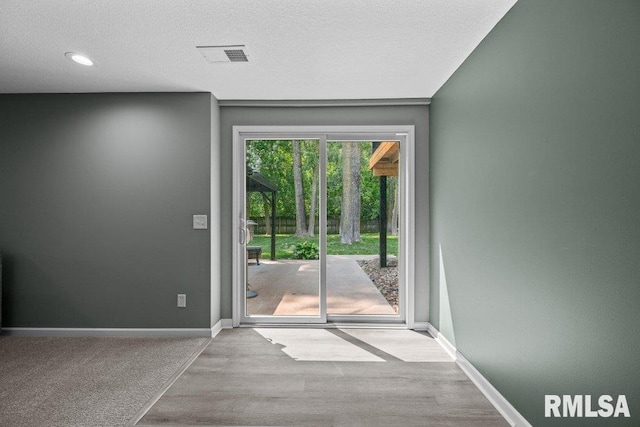 5300 Hillandale Rd, Davenport, IA 52806 - doorway to outside featuring wood finished floors, a textured ceiling, and recessed lighting