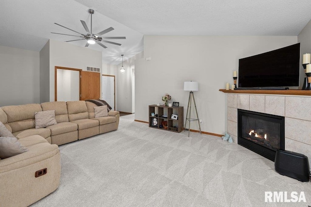 5300 Hillandale Rd, Davenport, IA 52806 - carpeted living room with vaulted ceiling, ceiling fan, and a tile fireplace