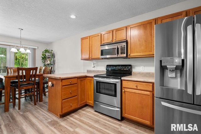 5300 Hillandale Rd, Davenport, IA 52806 - kitchen with stainless steel appliances, a textured ceiling, a peninsula, light countertops, and light wood-style flooring