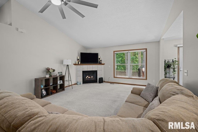 5300 Hillandale Rd, Davenport, IA 52806 - living room featuring light colored carpet, vaulted ceiling, a ceiling fan, a tiled fireplace, and a textured ceiling