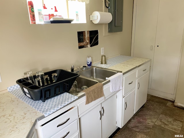 532 8th Ave S, Clinton, IA 52732 - kitchen featuring electric panel, light countertops, white cabinetry, and a sink