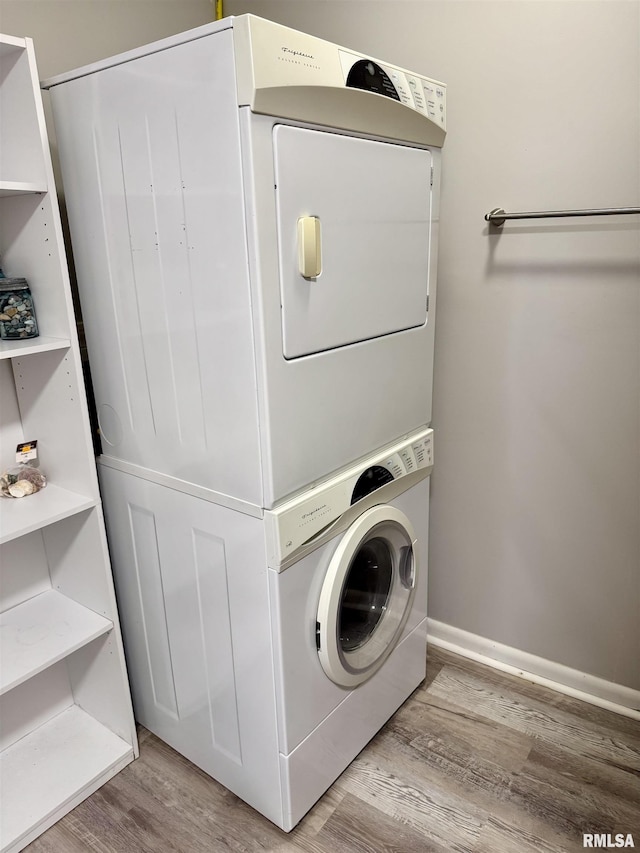 532 8th Ave S, Clinton, IA 52732 - washroom with stacked washer and clothes dryer, wood finished floors, and baseboards