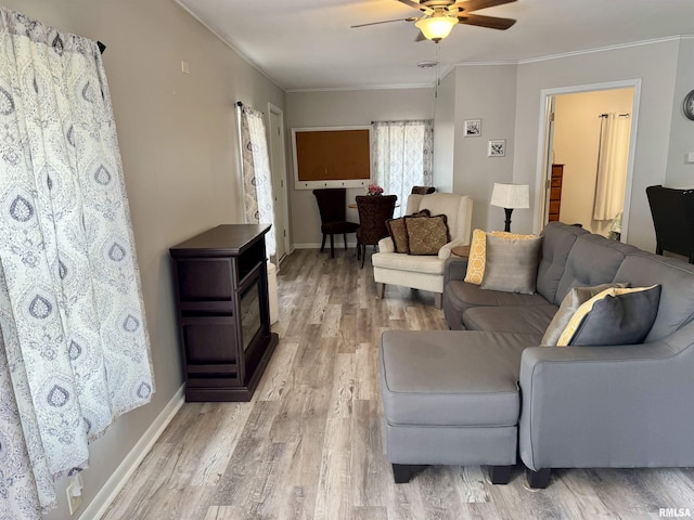 532 8th Ave S, Clinton, IA 52732 - living room featuring ceiling fan, light wood finished floors, crown molding, baseboards, and a wood stove