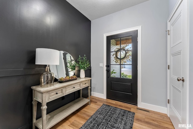 701 Sweet Wood Ln, Blue Grass, IA 52726 - entryway featuring light wood-style flooring and a textured ceiling
