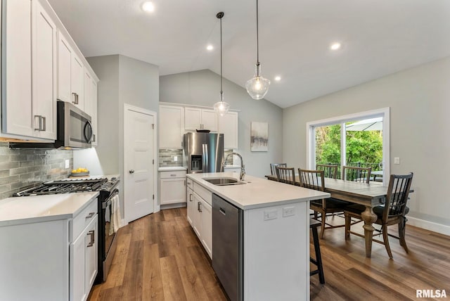 701 Sweet Wood Ln, Blue Grass, IA 52726 - kitchen with stainless steel appliances, light countertops, dark wood-type flooring, a kitchen bar, and a kitchen island with sink