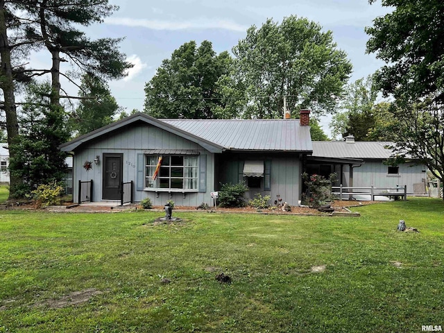 1210 Peterson Ave, Johnston City, IL 62951 - view of front of property featuring a chimney, a front lawn, metal roof, and board and batten siding