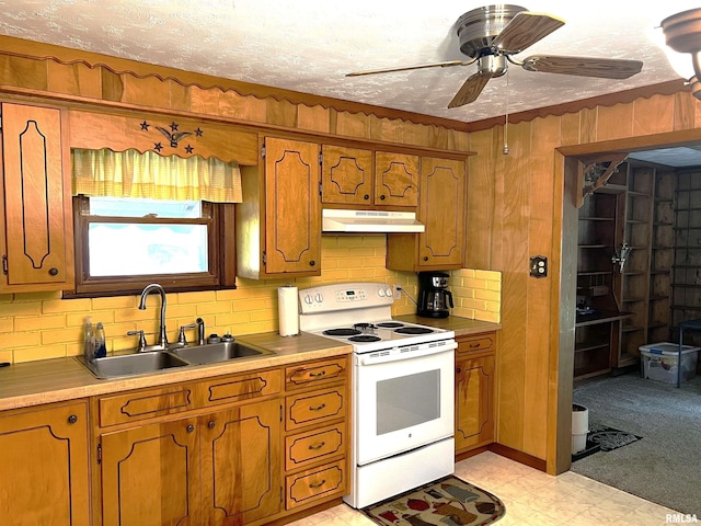1210 Peterson Ave, Johnston City, IL 62951 - kitchen with white range with electric cooktop, under cabinet range hood, a sink, brown cabinetry, and backsplash