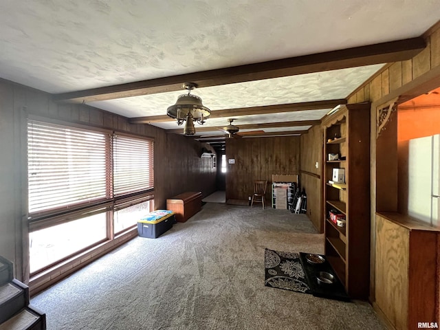 1210 Peterson Ave, Johnston City, IL 62951 - unfurnished living room featuring carpet floors, wood walls, ceiling fan, and beamed ceiling
