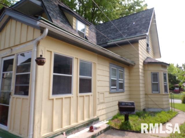 1522 Brady St, Davenport, IA 52803 - view of side of home with roof with shingles and board and batten siding