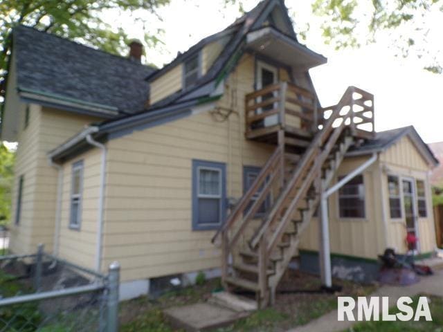 1522 Brady St, Davenport, IA 52803 - rear view of house with a balcony, stairway, board and batten siding, and a chimney