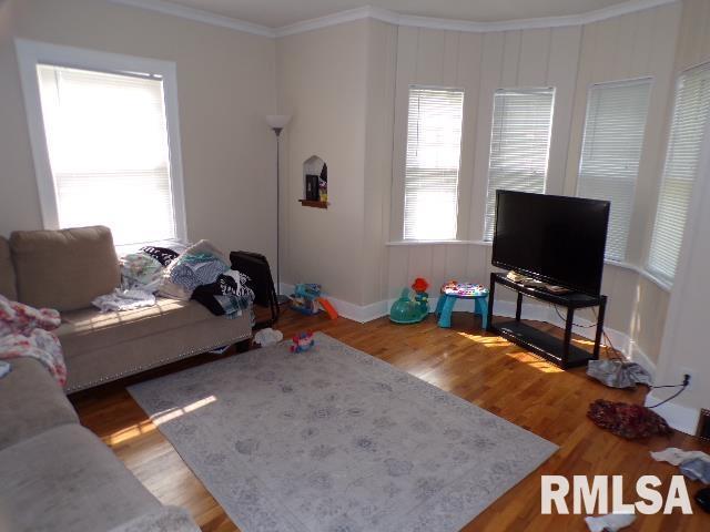 1522 Brady St, Davenport, IA 52803 - living area featuring crown molding, wood finished floors, and baseboards
