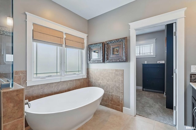 7 Redstone Ct, Le Claire, IA 52753 - bathroom featuring tile walls, a freestanding tub, and tile patterned flooring
