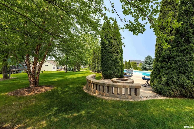 7 Redstone Ct, Le Claire, IA 52753 - view of grassy yard with a fire pit, a patio area, and an outdoor pool