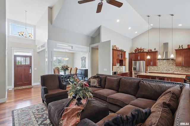 7 Redstone Ct, Le Claire, IA 52753 - living room featuring high vaulted ceiling, ceiling fan, light wood-style flooring, plenty of natural light, and a chandelier