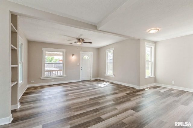 2320 E High St, Davenport, IA 52803 - unfurnished living room featuring healthy amount of natural light, wood finished floors, baseboards, and a ceiling fan