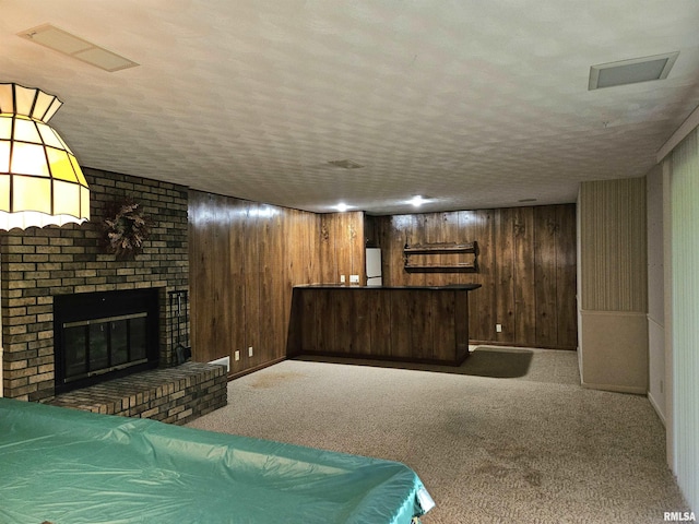 2120 Fareway Dr, Muscatine, IA 52761 - bar with carpet floors, wood walls, a fireplace, and a textured ceiling