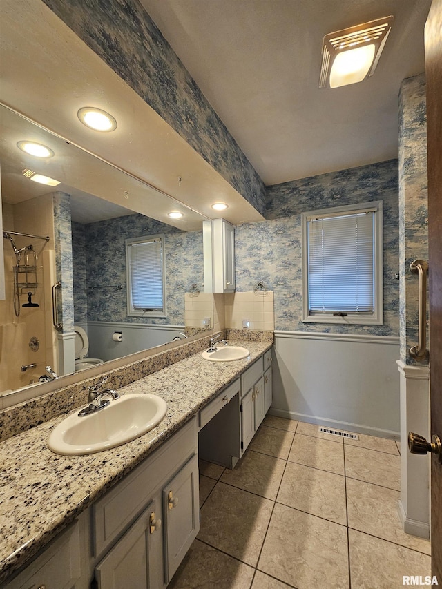 2120 Fareway Dr, Muscatine, IA 52761 - bathroom with tile patterned floors, wallpapered walls, double vanity, toilet, and  shower combination