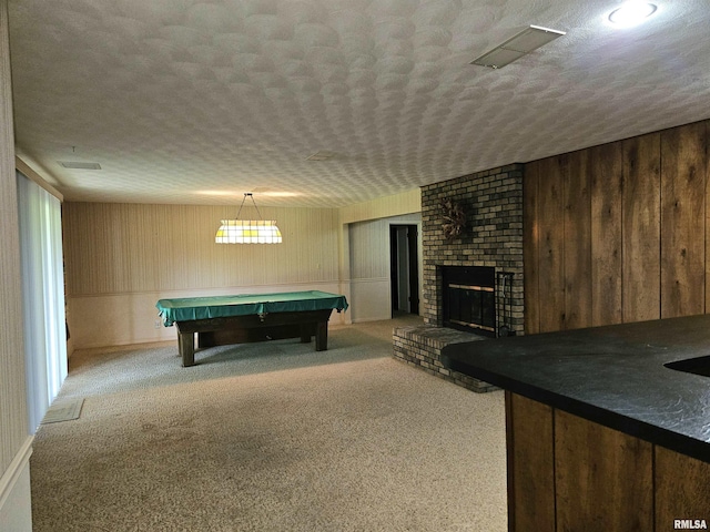 2120 Fareway Dr, Muscatine, IA 52761 - recreation room with wood walls, pool table, a textured ceiling, carpet flooring, and a brick fireplace