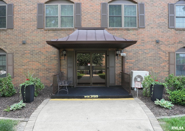 1360 Kimberly Ridge Rd Unit 313, Bettendorf, IA 52722 - view of exterior entry with french doors, a standing seam roof, and brick siding