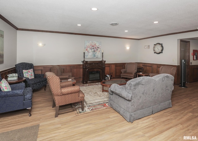 1360 Kimberly Ridge Rd Unit 313, Bettendorf, IA 52722 - living room featuring a wainscoted wall, light wood finished floors, crown molding, recessed lighting, and a glass covered fireplace