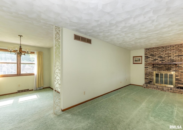1523 7th St, Orion, IL 61273 - unfurnished living room featuring a chandelier, a textured ceiling, carpet, baseboards, and a fireplace