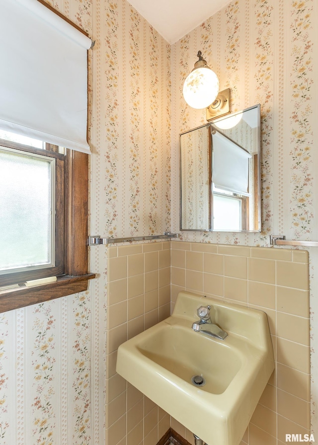 1523 7th St, Orion, IL 61273 - bathroom with wallpapered walls, tile walls, a sink, and a wainscoted wall