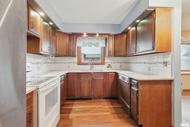 803 Locust St, Princeton, IA 52768 - kitchen with white electric range oven, a sink, light wood-type flooring, dishwashing machine, and backsplash