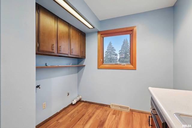 803 Locust St, Princeton, IA 52768 - laundry room with cabinet space, light wood-type flooring, and baseboards