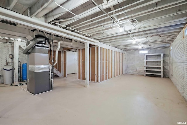 803 Locust St, Princeton, IA 52768 - unfinished basement with brick wall, heating unit, and a water pressure tank