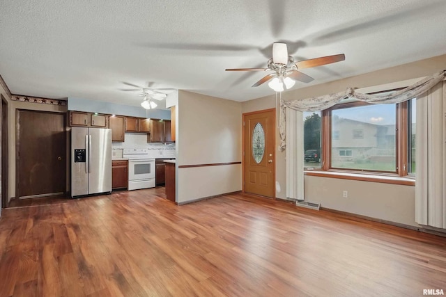 803 Locust St, Princeton, IA 52768 - kitchen featuring stainless steel refrigerator with ice dispenser, white electric stove, a ceiling fan, a textured ceiling, and wood finished floors