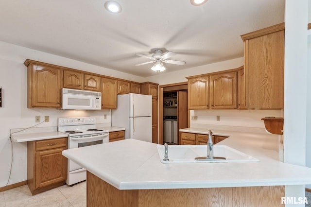 1530 N Pine St, Davenport, IA 52804 - kitchen with white appliances, a sink, a peninsula, washer / clothes dryer, and a ceiling fan